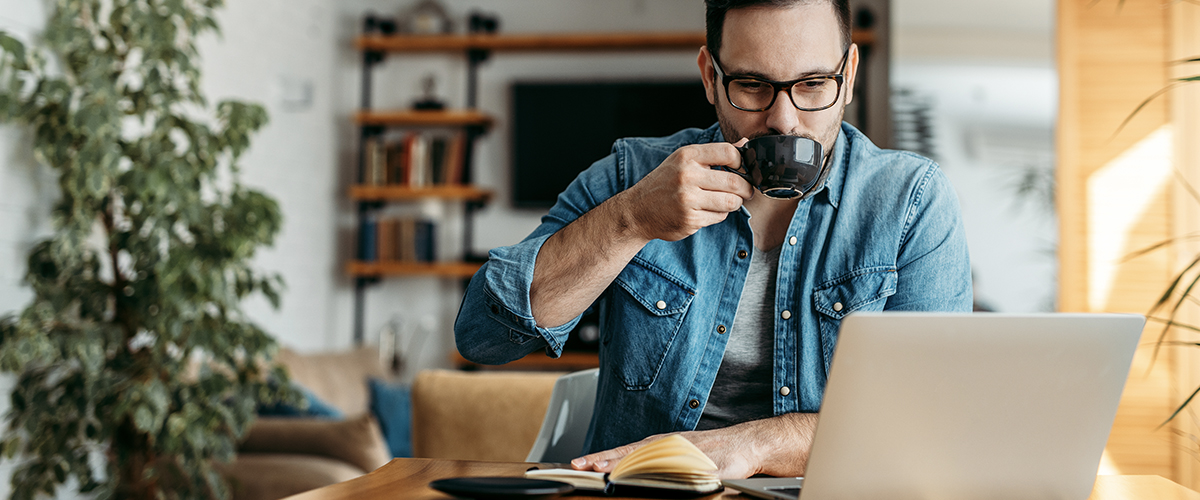 man at home with coffee and laptop
