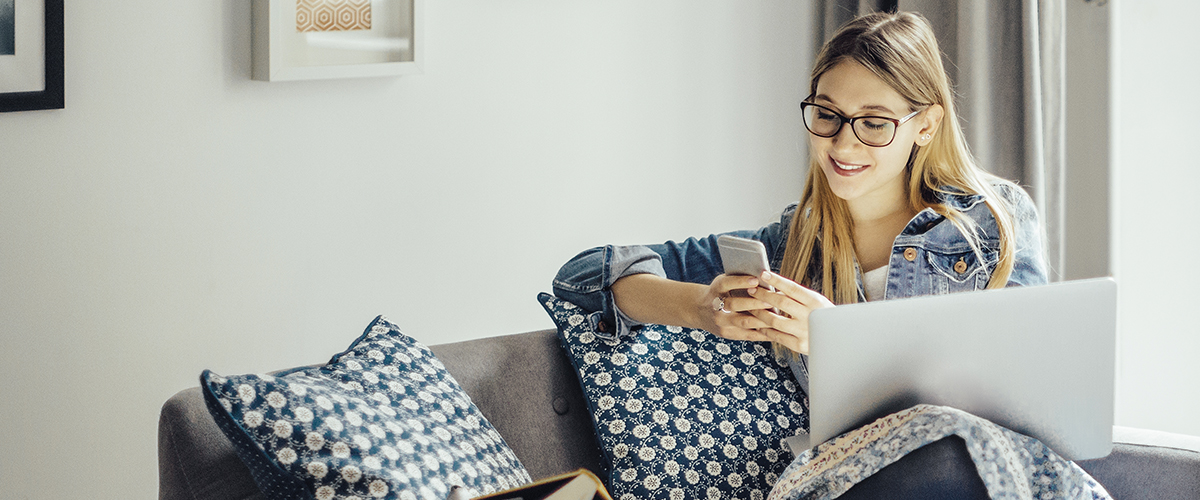 a woman relaxing on a sofa, studying on a phone