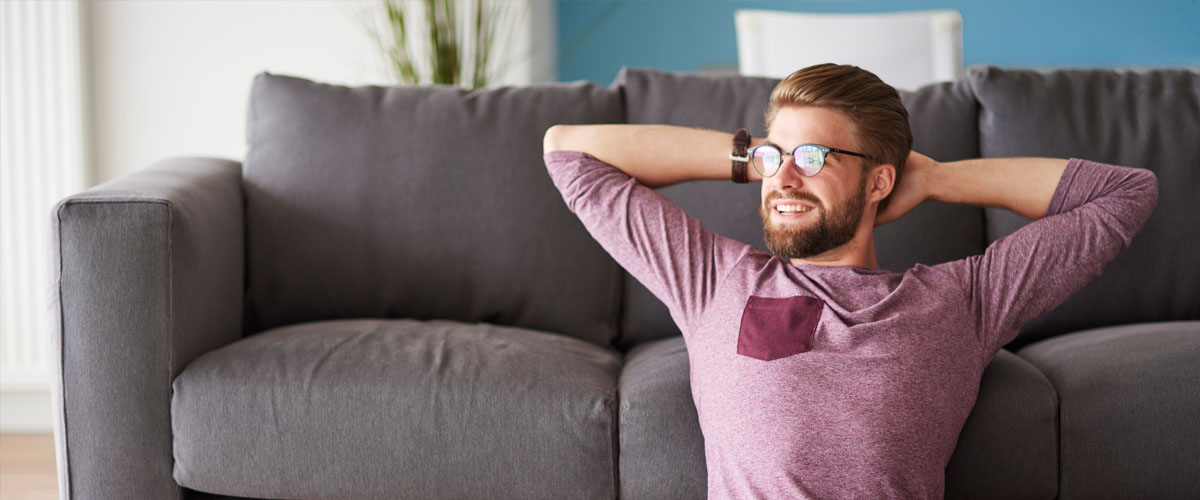 A relaxed man at home by his sofa studying AAT Level 3 bookkeeping